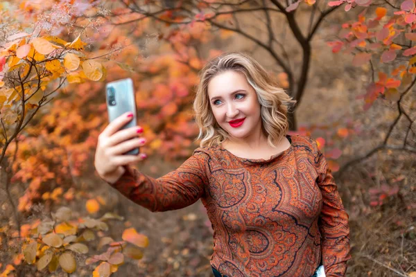 Молода Жінка Фоні Осіннього Парку Бере Селфі Свій Телефон — стокове фото