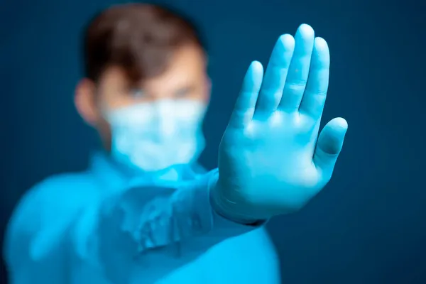 青い制服の医者は彼の手のひらの前に手を置き 記号を示しています — ストック写真