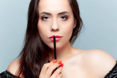 Esmer model bir dudak kalemi kullanmış ve onları boyamış.