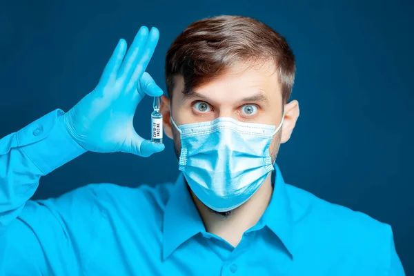 Arts Een Medisch Masker Handschoenen Gekleed Een Blauw Uniform Houdt — Stockfoto