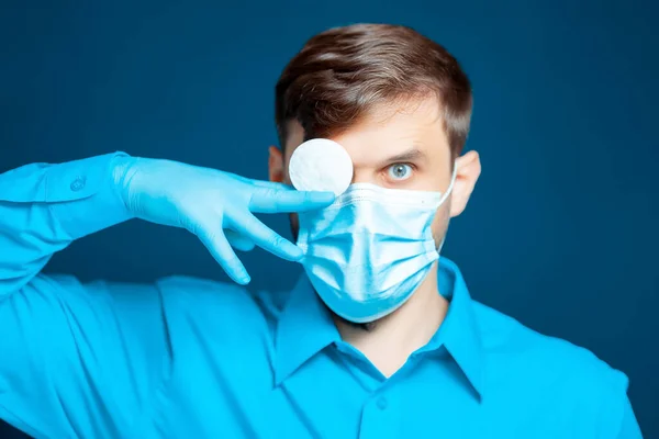 Een Arts Een Medisch Masker Handschoenen Een Blauw Uniform Houdt — Stockfoto