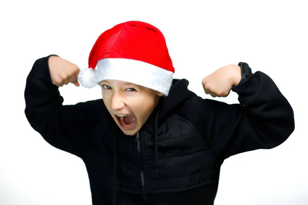 Мальчик Красной Шляпе Санта Показывает Угрожающие Жесты Усмехается — стоковое фото