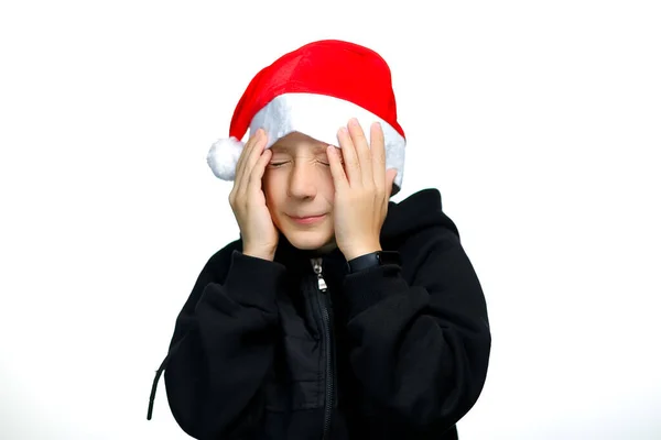 Kırmızı Noel Baba Şapkalı Bir Çocuk Korkudan Gözlerini Kapatıyor — Stok fotoğraf