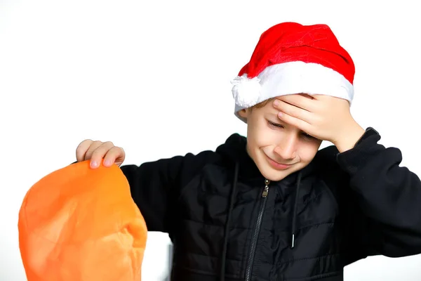 Kırmızı Noel Baba Şapkalı Bir Çocuk Başını Tutuyor — Stok fotoğraf