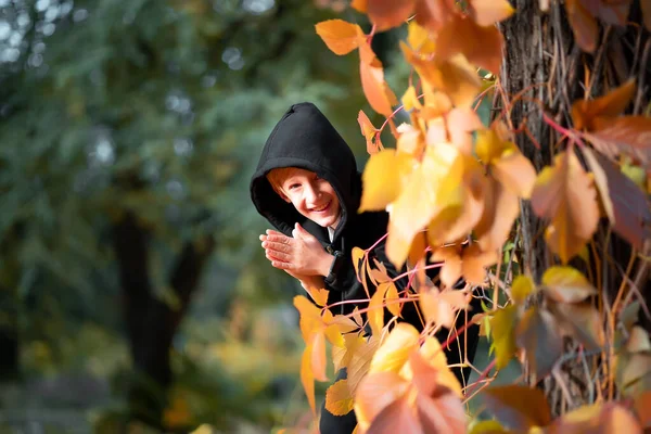 Chłopiec Czarnych Ubraniach Stoi Blisko Drzewa Którym Wiszą Żółte Jesienne — Zdjęcie stockowe