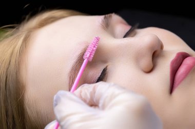 Kaşların katmanı, usta, modelin kaşlarını fırçayla tarar ve kaşlara jöle sürer.