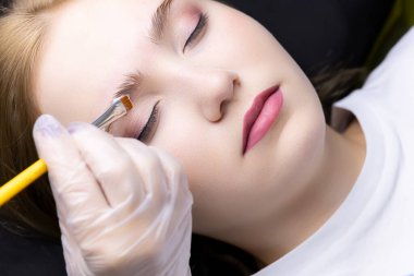 Usta kaş kaplama formüllerini kaş modellerine uyguluyor.