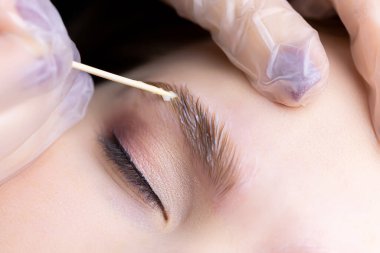 Kaş kıllarının makrografisi lamine bileşiklerin uygulandığı tahta bir çubukla kaşların üzerine yayılır.