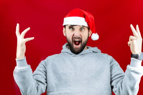 一个戴着红色圣诞老人帽的男人用他的手和双手做不同的姿势和手势 大叫着 — 图库照片