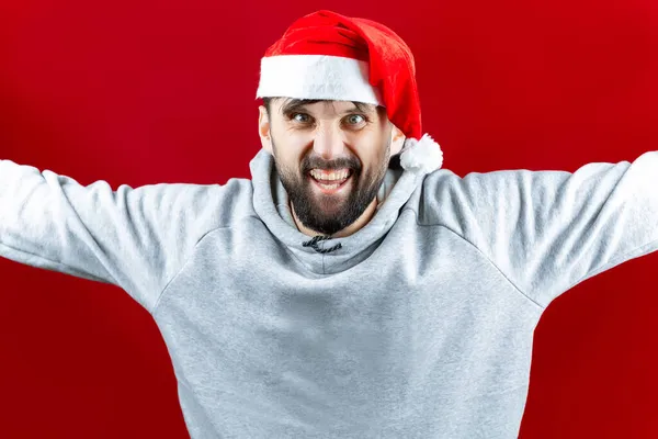 サンタクロースの帽子の明るい男が腕を横に広げ笑顔で — ストック写真