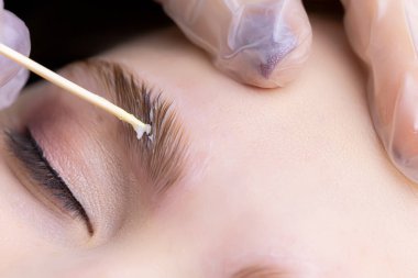 Kaş kıllarının makrografisi lamine bileşiklerin uygulandığı tahta bir çubukla kaşların üzerine yayılır.