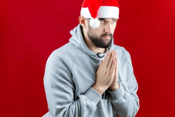 Fundo Vermelho Natal Homem Chapéu Papai Noel Dobrou Mãos Frente — Fotografia de Stock