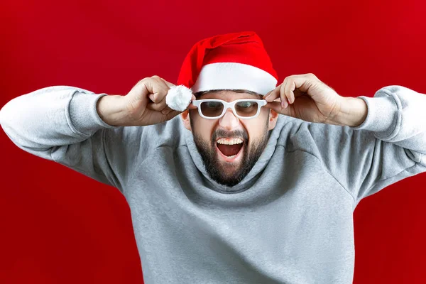 Brodaty Mężczyzna Kapeluszu Świętego Mikołaja Ogląda Świąteczne Filmy Okularami Gestami — Zdjęcie stockowe