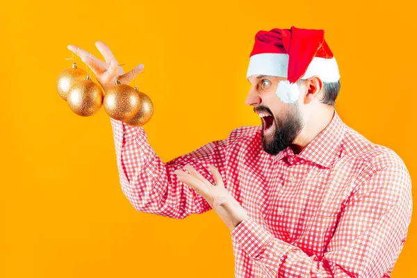 Ein Mann Mit Weihnachtsmütze Hält Weihnachtsspielzeug Kugeln Und Rufe Der — Stockfoto