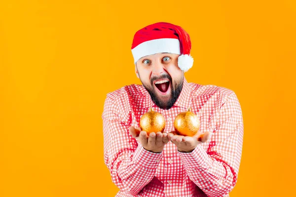 Ein Fröhlicher Mann Mit Nikolausmütze Auf Weihnachtsgelbem Hintergrund Hält Goldene — Stockfoto