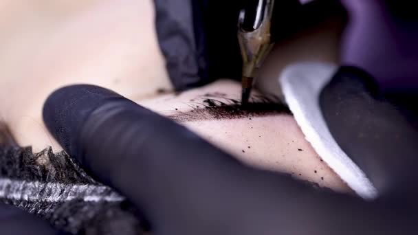 Close-up, η βελόνα της μηχανής τατουάζ φέρνει χρωστική ουσία στα φρύδια. — Αρχείο Βίντεο