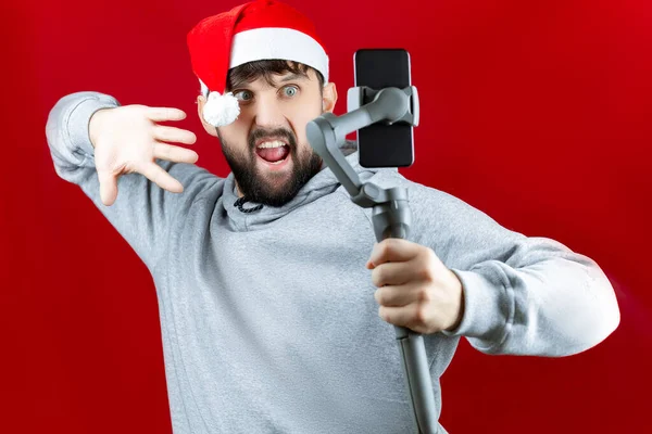 Весела Людина Червоному Капелюсі Санта Клауса Тримає Електронний Стабілізатор Руці — стокове фото