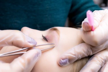 Kaplama işleminden sonra, kaşların yakın çekimi, ana cımbız kılları koparmak için