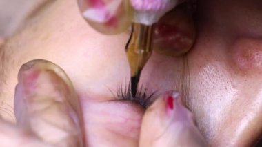 Dövme makinesi kullanarak göz kapağının kalıcı makyajının üst görüntüsü.