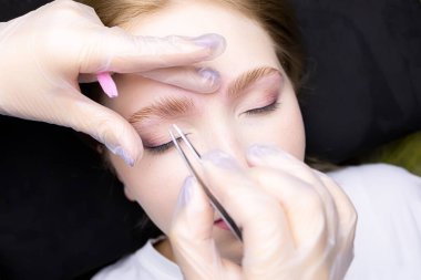 Ustanın elleri, taranmış kaşları katmandan sonra kompozisyonlarla düzeltir.