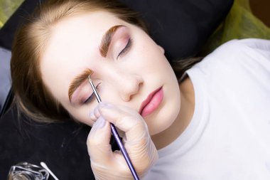 Modelin kaşları, katman işleminden sonra saçların bileşiklerle renklendirilmesi için kalın bir kat boya ile uygulanır.