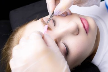 Modelin kaşlarının cımbızla düzeltilmesi ve kat ve boyama işleminden sonra kaşların çevresindeki fazla kılların alınması.