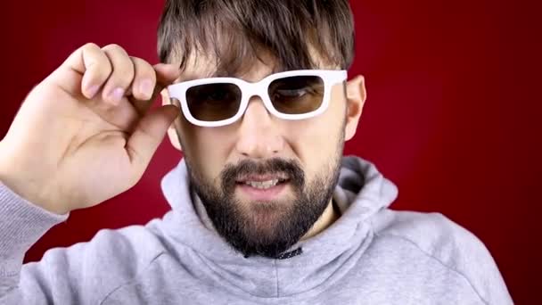 Primo piano di un uomo barbuto che toglie occhiali bianchi per i film — Video Stock