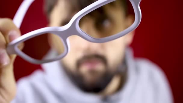 De man toont de bril aan de camera en zet deze dan op — Stockvideo