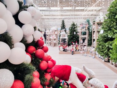 Noel ağaçları, oyuncaklar ve çeşitli çelenklerle süslenmiş alışveriş merkezi manzarası.