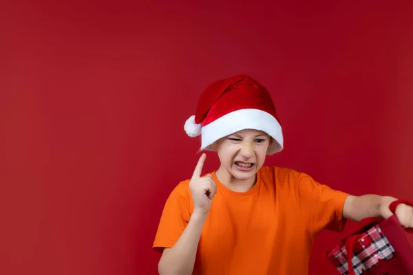 Uma Criança Fundo Vermelho Chapéu Papai Noel Está Segurando Saco — Fotografia de Stock