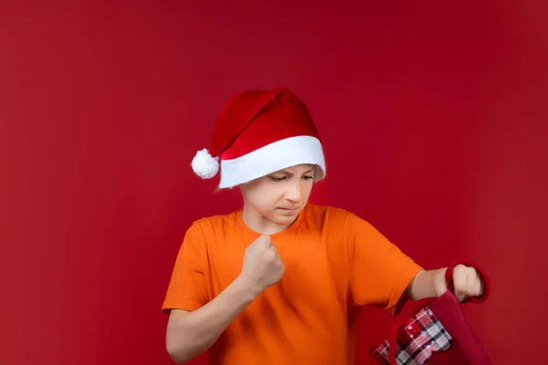 Sarı Tişörtlü Noel Baba Şapkalı Bir Çocuk Elinde Bir Hediye — Stok fotoğraf