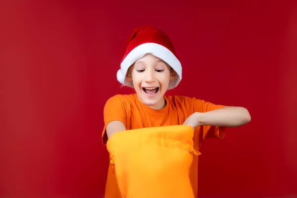 Menino Feliz Chapéu Papai Noel Enfiou Mão Saco Presente Amarelo — Fotografia de Stock