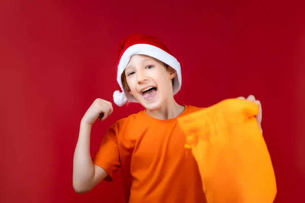 Веселый Мальчик Шляпе Санты Держит Новогоднюю Сумку Подарками Руках — стоковое фото