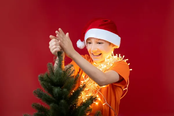 Menino Engraçado Chapéu Papai Noel Segura Topo Árvore Natal Alegremente — Fotografia de Stock