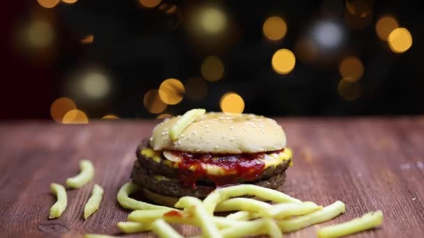 Hamburger auf dem Hintergrund des Weihnachtsbaums — Stockvideo