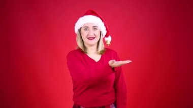 Güzel sarışın kadın Noel Baba şapkası ve kırmızı elbiseler giyiyor.