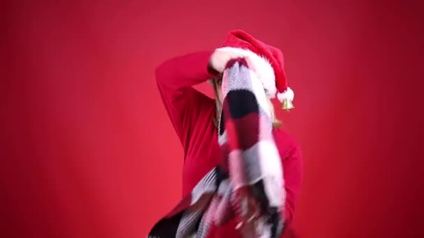 Blond in een santa hoed zet op een geruite ruit — Stockvideo