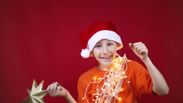 der Junge hat einen goldenen Stern in der Hand auf dem Weihnachtsbaum