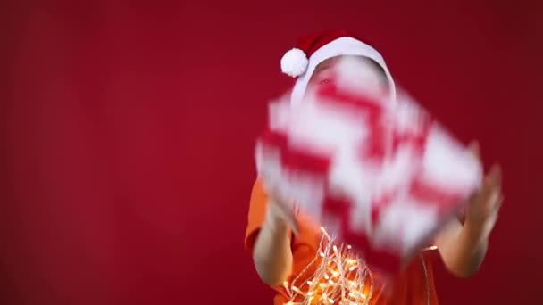 Dítě v klobouku Santa Claus David vánoční dárek a pak hodí — Stock video