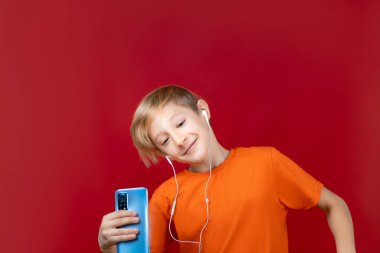 Neşeli çocuk kulaklıkla dans edip müzik dinliyor.