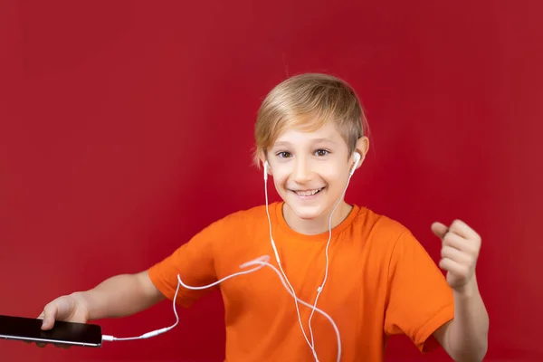 Schöner Lächelnder Junge Auf Rotem Hintergrund Hält Ein Handy Der — Stockfoto