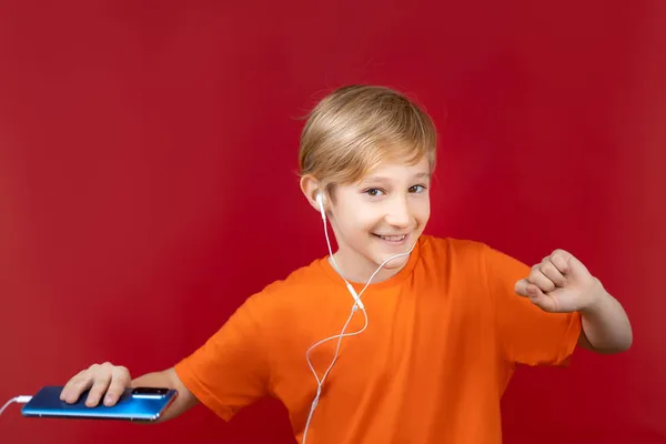 Schöner Lächelnder Junge Auf Rotem Hintergrund Hält Ein Handy Der — Stockfoto