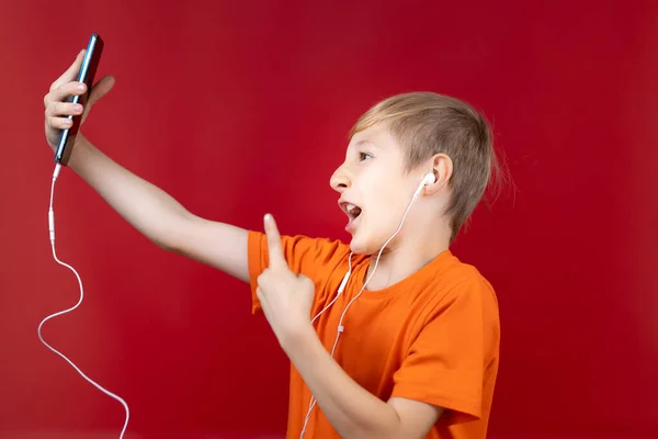 Niño Con Auriculares Sosteniendo Teléfono Azul Delante Mostrando Varios Gestos — Foto de Stock