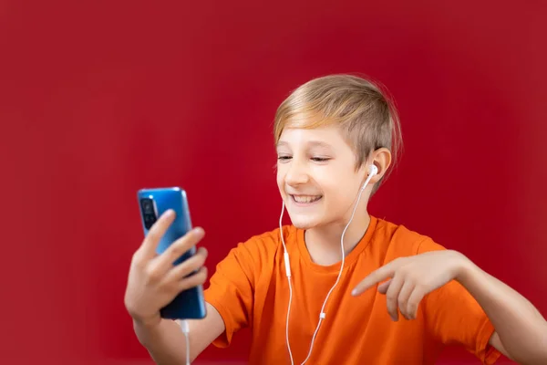 Menino Alegre Fundo Vermelho Segura Telefone Sua Mão Gestos Emocionalmente — Fotografia de Stock