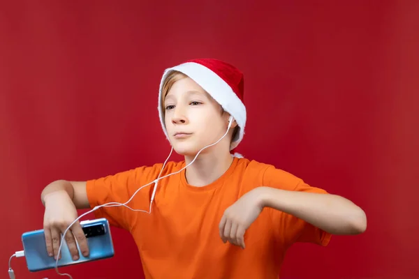 Ένα Αγόρι Που Χορεύει Κόκκινο Φόντο Κρατώντας Ένα Τηλέφωνο Στο — Φωτογραφία Αρχείου