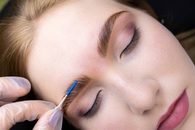 Beyaz eldivenli bir ustanın kompozisyonlarıyla kapladıktan sonra odunların makro fotoğraflanması saçların uzamasına göre kaşları tarar.