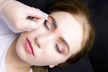 Kompozisyonların yardımıyla kaş katlama prosedüründen sonra usta, mavi fırçaların yardımıyla kaşlara saç teli takar.
