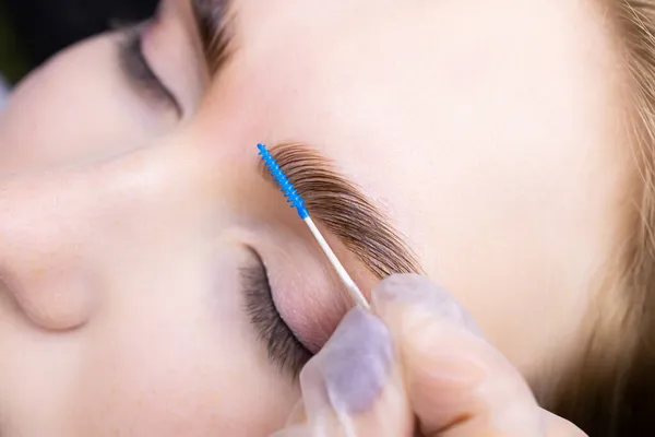 Pentear Cabelos Após Laminação Das Sobrancelhas Com Uma Escova Azul — Fotografia de Stock