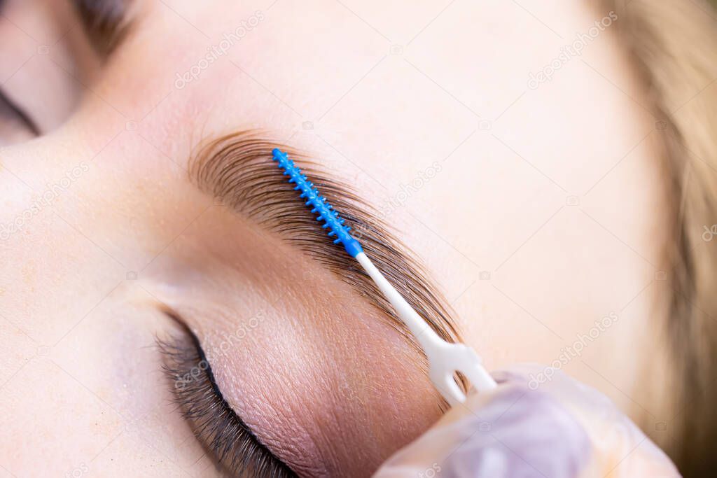 completed eyebrow lamination procedure the master combs the eyebrows of the eyebrow combs