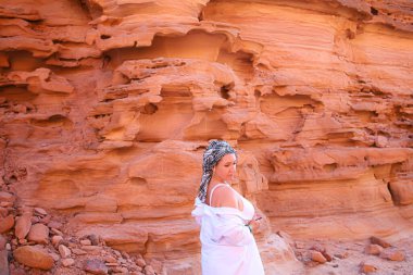 Güzel bir kadın kayalık bir geçitin arka planında